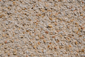 A wall with a white and tan stone surface