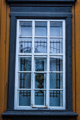 Close-up photo of a traditional Norwegian house's window, on a cloudy day
