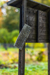 Dirty computer keyboard hanging from a wooden bulletin board.