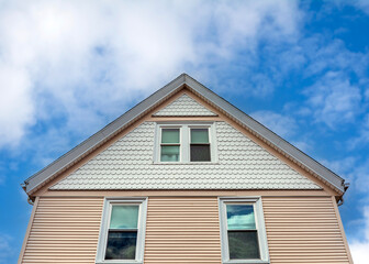 Elegant house facade with scalloped shingles and horizontal clapboards in Brighton, Massachusetts, USA
