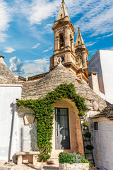 Group of beautiful Trulli, traditional Apulian dry stone hut old houses with a conical roof in Itria Valley, Puglia, Italy