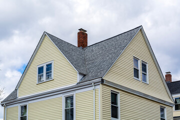 Charming residence with steeply pitched roof and white trim in Brighton, Massachusetts, USA
