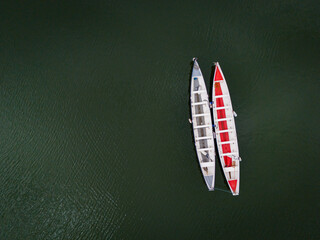 2 long row boats on a lake shot by drone
