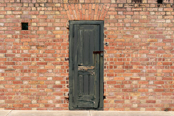 An old weathered wooden door in a brick wall