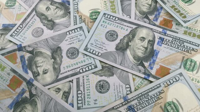 This is a closeup image showing stacks of U.S. hundred dollar bills from a top view