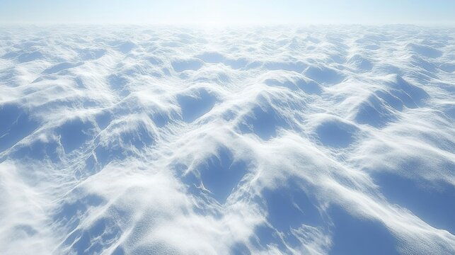 Aerial View of a Vast, Undulating Snowscape Under a Bright Sky