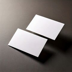 Two blank business cards placed at a slight angle, hovering over a neutral dark background