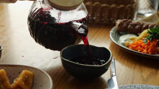 Pouring traditional hibiscus tea into a bowl