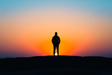 man silhouette against a sunrise or sunset, representing strength and inner power, minimal background with copy space 