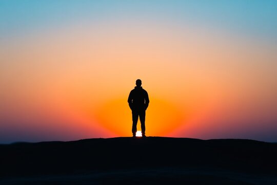 man silhouette against a sunrise or sunset, representing strength and inner power, minimal background with copy space 