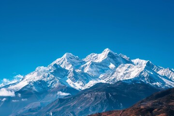 Fototapeta premium A panoramic view of snow-capped mountains against a vibrant blue sky, Snow-capped mountains under a clear blue sky