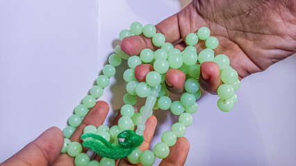 100 beads or prayer beads, held, white background