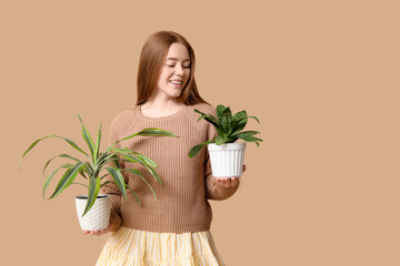 Pretty young woman with houseplants on beige background