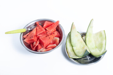 Closeup of watermelon with a spoon in bowls on a white background and watermelon rinds on a plate...