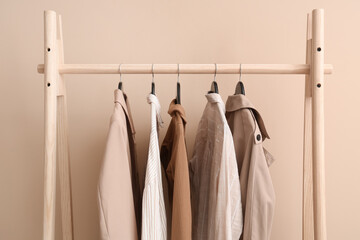 Female clothes hanging on rack against beige background