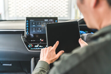 自動車の車内でタブレットを使い・メンテナンス・修理・チェック・点検する男性作業員

