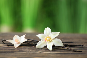 Fototapeta premium Aromatic vanilla pods and flowers on table outdoors