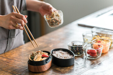 キッチンでお弁当を詰める女性の手元（愛妻弁当）
