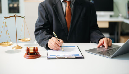 justice and law concept.Male judge in a courtroom  the gavel, working with tablet on table .