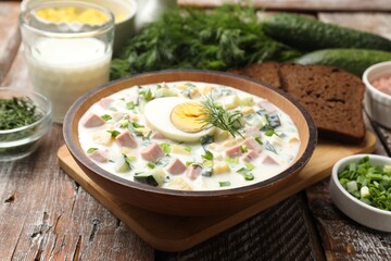 Delicious okroshka soup with kefir served on wooden table, closeup