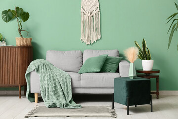 Interior of living room with sofa and green pouf