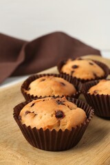 Delicious muffin with chocolate chips on table, closeup