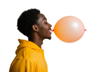 a front view image of a 18 year old african american male leaning in and blowing up a ballon, head turned in profile to one side, happy, yellow orange hooded sweatshirt, on a white background