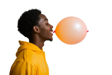 a front view image of a 18 year old african american male leaning in and blowing up a ballon, head turned in profile to one side, happy, yellow orange hooded sweatshirt, on a white background