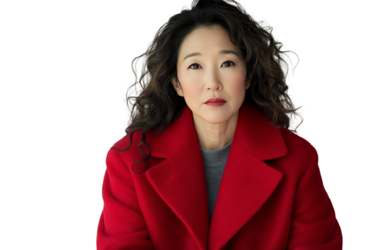 A front view shot of sitting, wearing a red wool coat, looking to the side with her eyes, on a white background