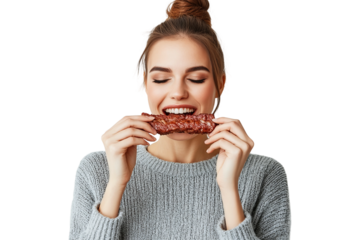 a 20 year woman about to take a bite of a beef stick, brown hair in a bun, on a white background
