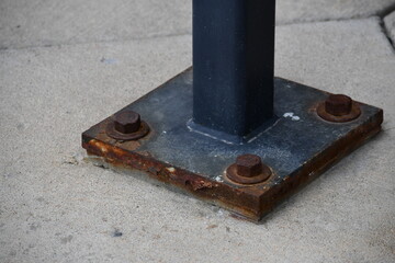 Steel baseplate bolted to concrete.