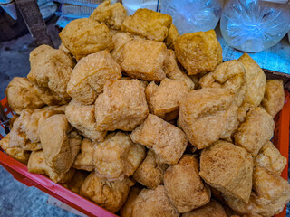 Golden Brown Fried Tofu Cubes in Red Plastic Basket at a Market