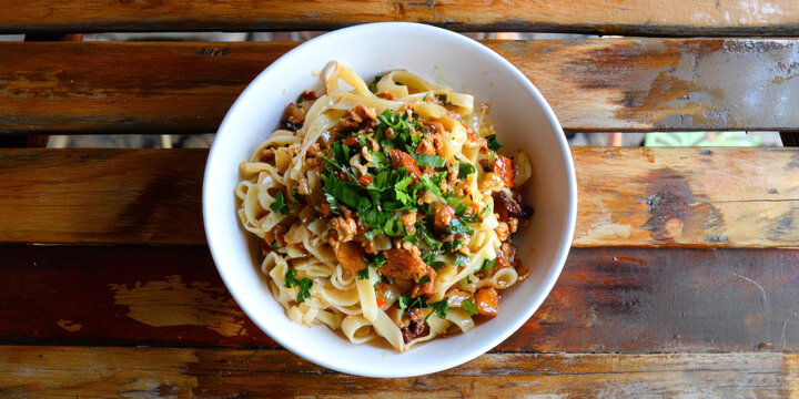 bowl of Burmese nan gyi thoke, thick rice noodle salad with herbs and spices