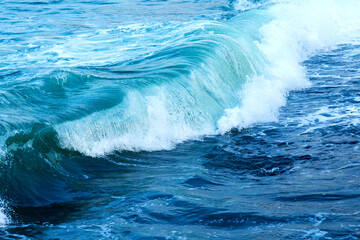 A stunning view of powerful ocean waves crashing with white foam against the deep blue sea. The dynamic movement and vibrant colors capture the raw beauty of nature, perfect for marine, travel, and en
