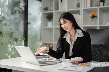 Cheerful businesswoman explaining financial concepts while working on a laptop.