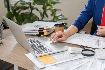 Accountant working on laptop and organizing financial documents