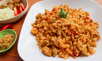 spicy fried rice with meatball, tomato, and cabbage as a complementary dishes. Indonesian food