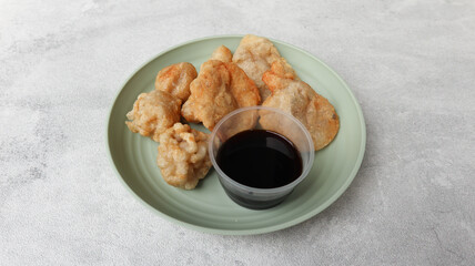 Pempek with cuko or vinegar sauce on white bowl. Pempek, mpek-mpek or empek-empek is a savory Indonesian fishcake delicacy, made of fish and tapioca, from Palembang, South Sumatera, Indonesia
