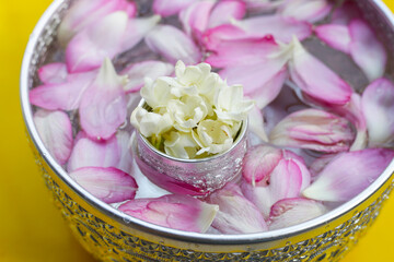 Water with jasmine flower, lotus petal in silver bowl. Thai tradition, Songkran festival concept