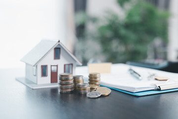 Rubber stamp calculator and loan house model on table with home loan approved on loan application...