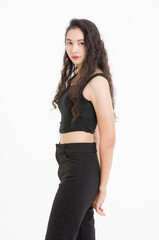 Portrait of asian beautiful woman with curly hair, wearing black tank top black long pants, model girl attractive confident cheerful standing smiling pose look at camera on white background in studio.