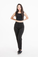 Portrait of full body asian beautiful woman with curly hair, wearing black tank top black long pants, model girl attractive confident standing smiling pose look at camera on white background in studio