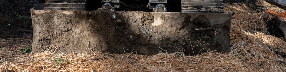 Obraz premium New housing construction site in earthworks stage, excavator with blade front to grade work site 