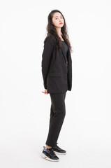 Portrait full body of asian beautiful woman curly long hair, wearing black suit, black long pants, model girl attractive confident charming, standing pose look at camera on white background in studio.
