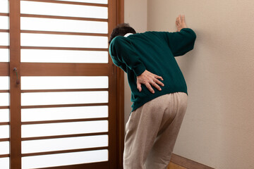 腰痛に悩む老人