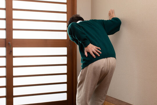 腰痛に悩む老人