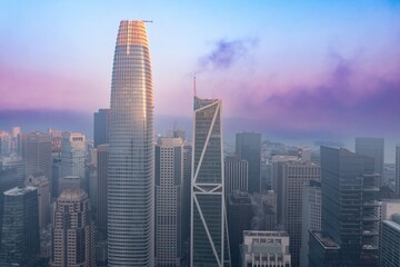 San Francisco, USA, skyline shrouded in fog. The Salesforce Tower and Transamerica Pyramid stand tall amidst the dense fog, creating an eerie yet captivating urban landscape.