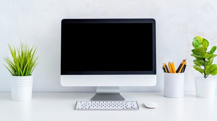 Modern Desktop Setup with Blank Screen and Green Plants on Table