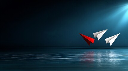 Red paper airplane leading white ones, reflecting on dark water.