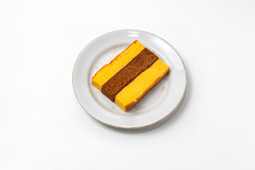 Lapis Surabaya or Surabaya layer cake, is an Indonesian three layer rich sponge cake and strawberry jam in between, isolated on white background